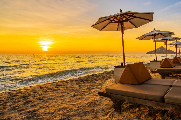 umbrella and chair with pillow around beautiful landscape of bea